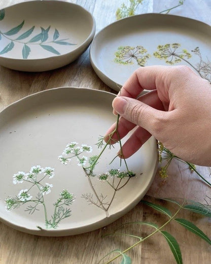 Model a ceramic vase and decorate it with flowers